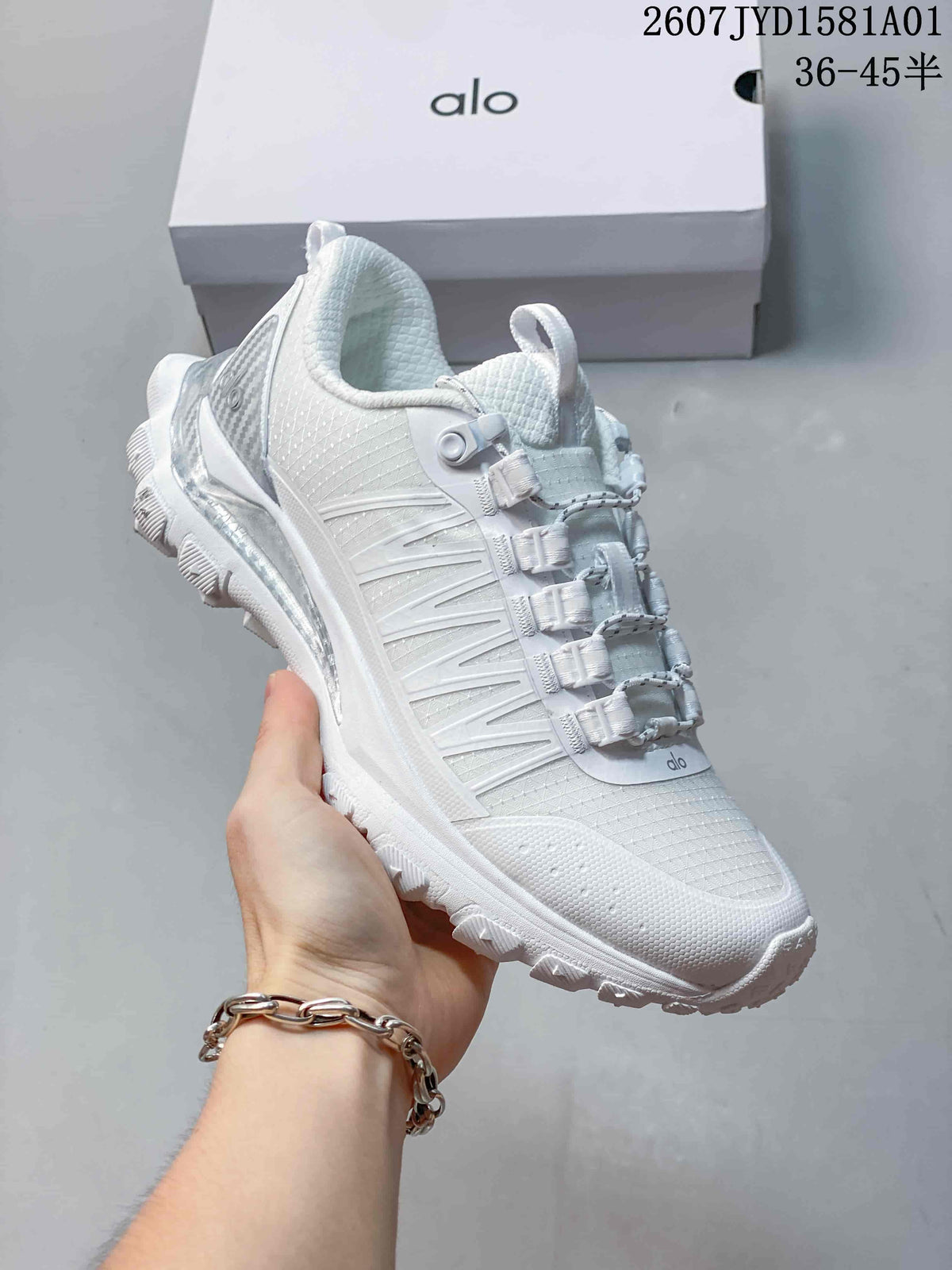 Close-up of a white Alo Trail sneaker showing its lace-up fastening and layered side panels.