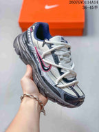Angled side view showing the gray and black upper, pink Swoosh accent, and low-top shape.