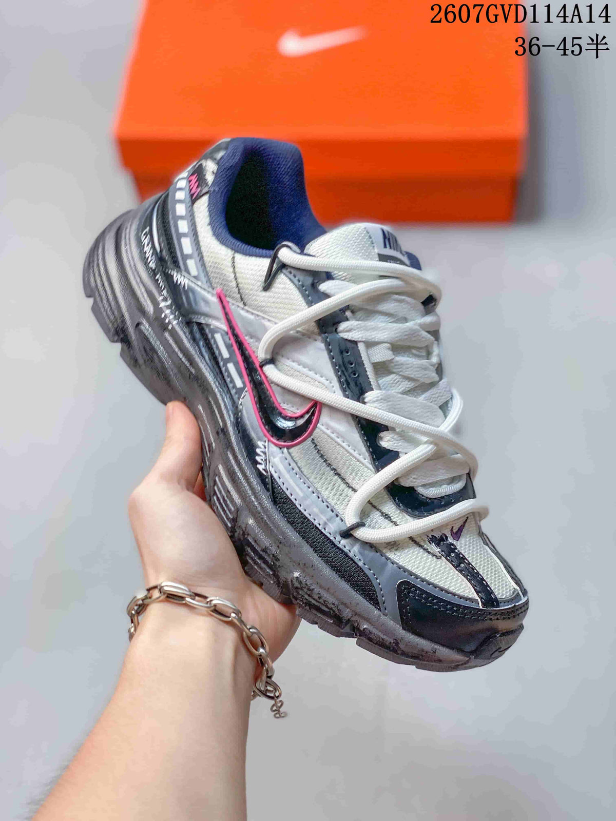 Angled side view showing the gray and black upper, pink Swoosh accent, and low-top shape.