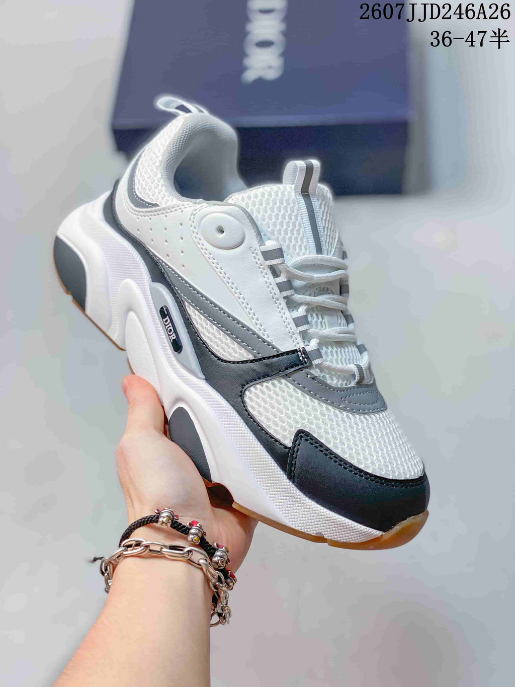 Angled side view of the Dior sneaker showing the rounded toe, lace-up design, layered upper, and chunky sole.