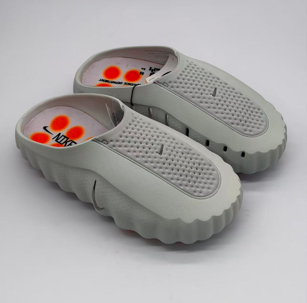 Top three-quarter view of gray Nike slide sandals showing the perforated footbeds and open-back design.