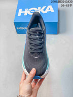 Top view of a charcoal lace-up HOKA running shoe with blue side accents.