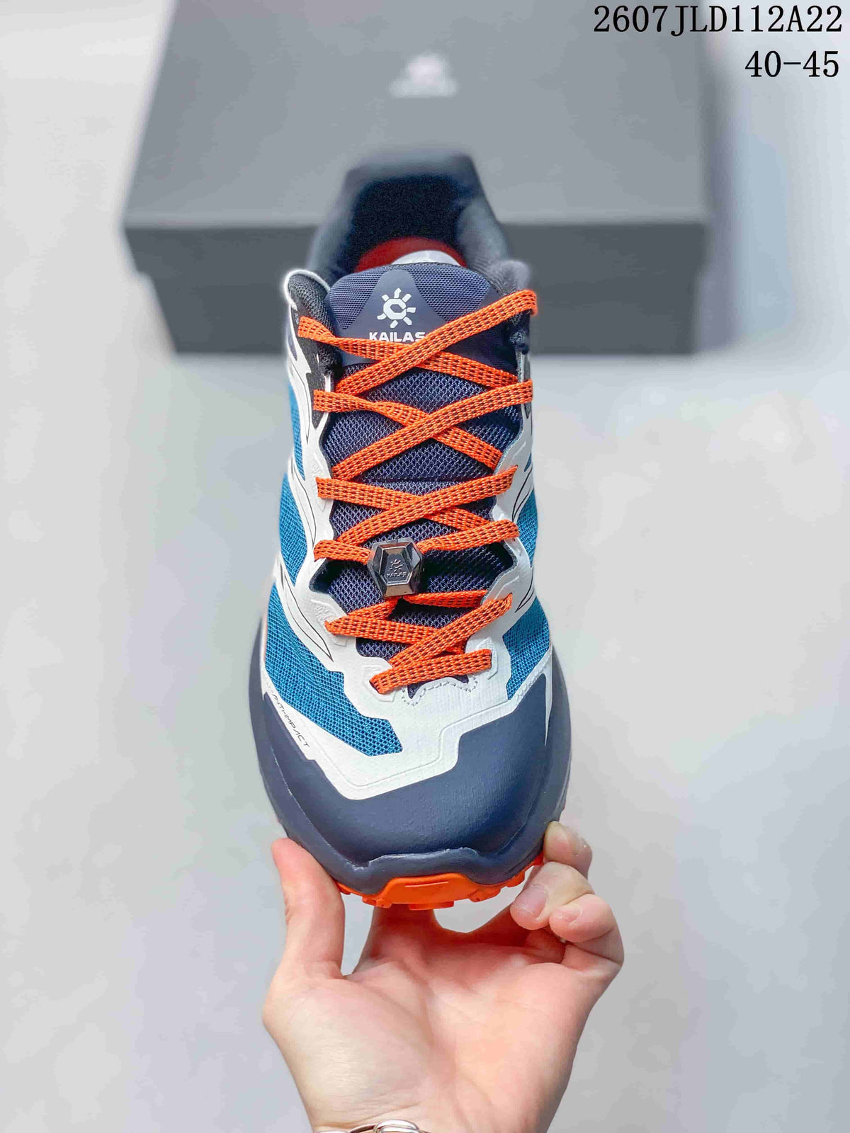 Front view of the Kailas C4 sneaker showing orange laces, a navy tongue, blue mesh panels, and a protective toe area.
