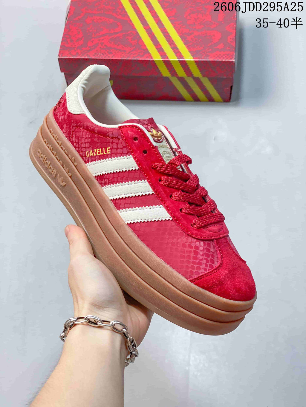 Close view of the sneaker's side with visible Gazelle lettering, white stripes, and red textured panels.