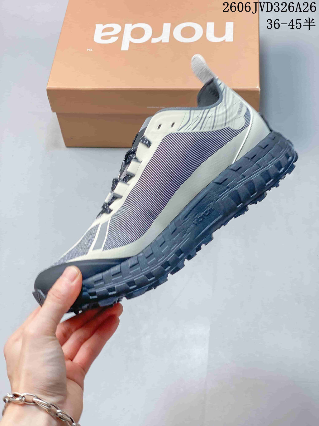 Side view of the gray and off-white norda trail-running shoe.
