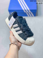 Angled view of one black and white sneaker with its side stripes and shell toe visible.