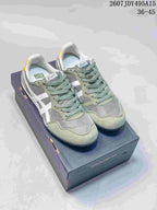 Pair of green and white Onitsuka Tiger Serrano sneakers displayed on a shoebox; style code 2607JDY495A15 and EU size range 36–45 are visible.