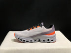 Side view of a gray On Cloud X sneaker with a lavender-gray heel panel and orange accents.