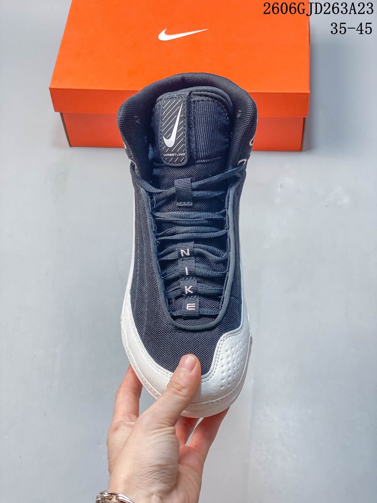 Front view of a navy and white Nike wrestling shoe with laces