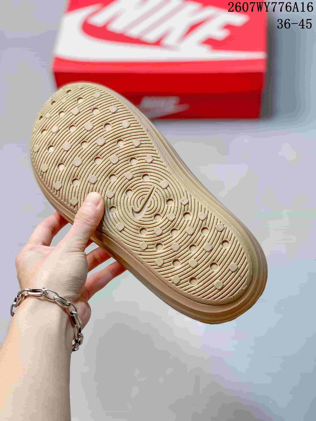 Close-up of the textured tan outsole showing circular traction elements and curved linear grooves.