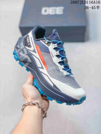 Angled side view of the KAILAS FUGA EX330 shoe with blue laces, gray mesh-style panels, orange accent, and lugged outsole.