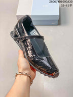 Angled view of the glossy black Mary Jane-style shoe and adjustable strap