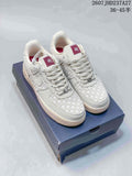 Pair of white and cream Nike Air Force 1 Retro PRM low-top sneakers with woven panels displayed on a dark shoe box.