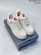 Pair of white and cream Nike Air Force 1 Retro PRM low-top sneakers with woven panels displayed on a dark shoe box.