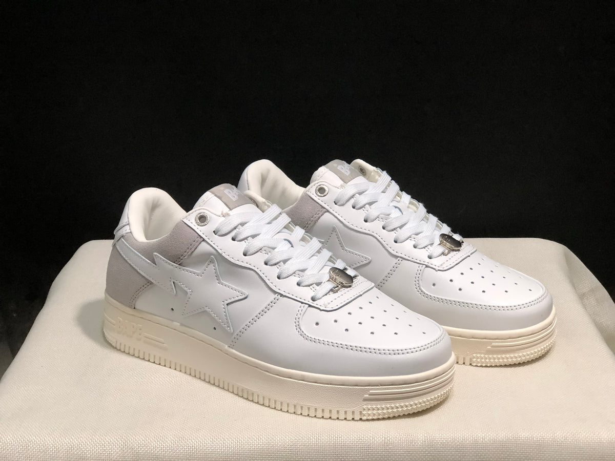 Three-quarter view showing the white and gray color blocking, star side details, and raised soles.