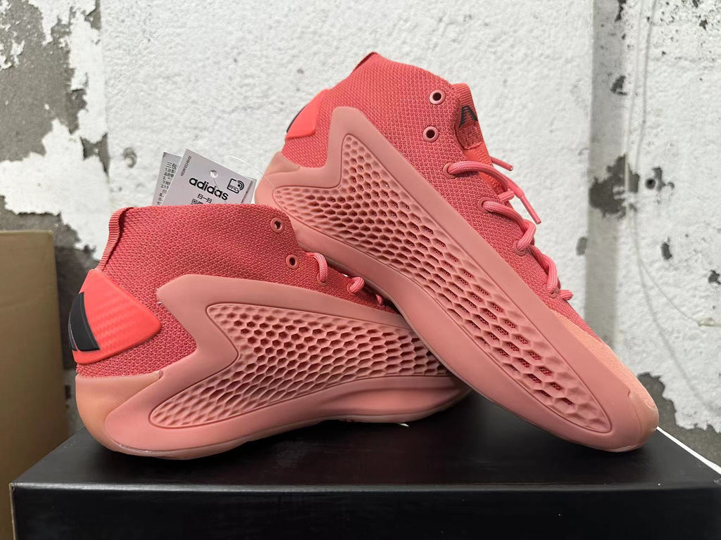 Pair of pink Adidas mid-top sneakers shown from the side, with a visible Adidas tag.