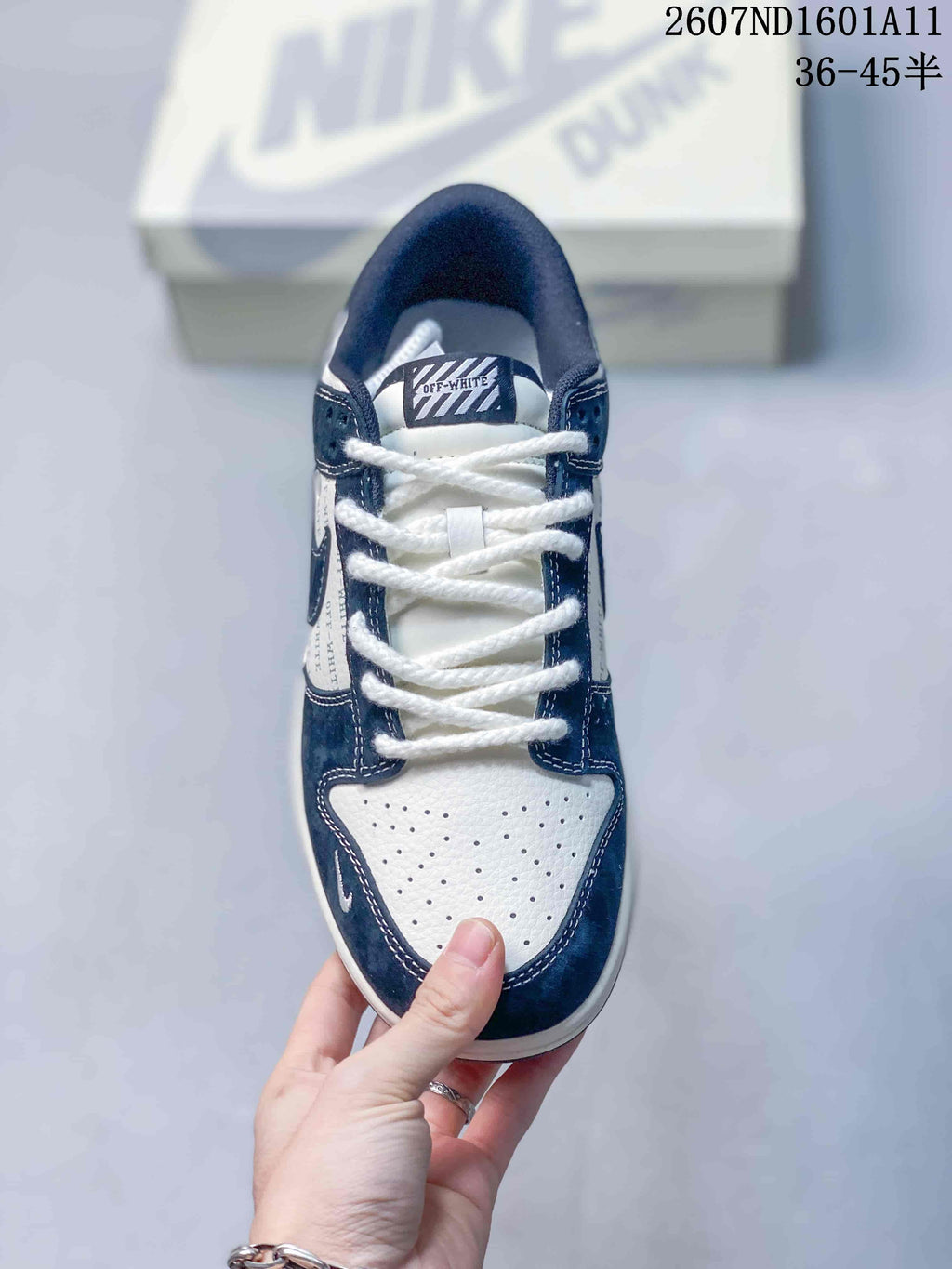 Top view showing white laces, perforated white toe box, navy overlays, and OFF-WHITE-branded tongue label.