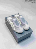 Pair of gray and white Onitsuka Tiger Mexico 66 Sabot sneakers displayed on a shoebox.