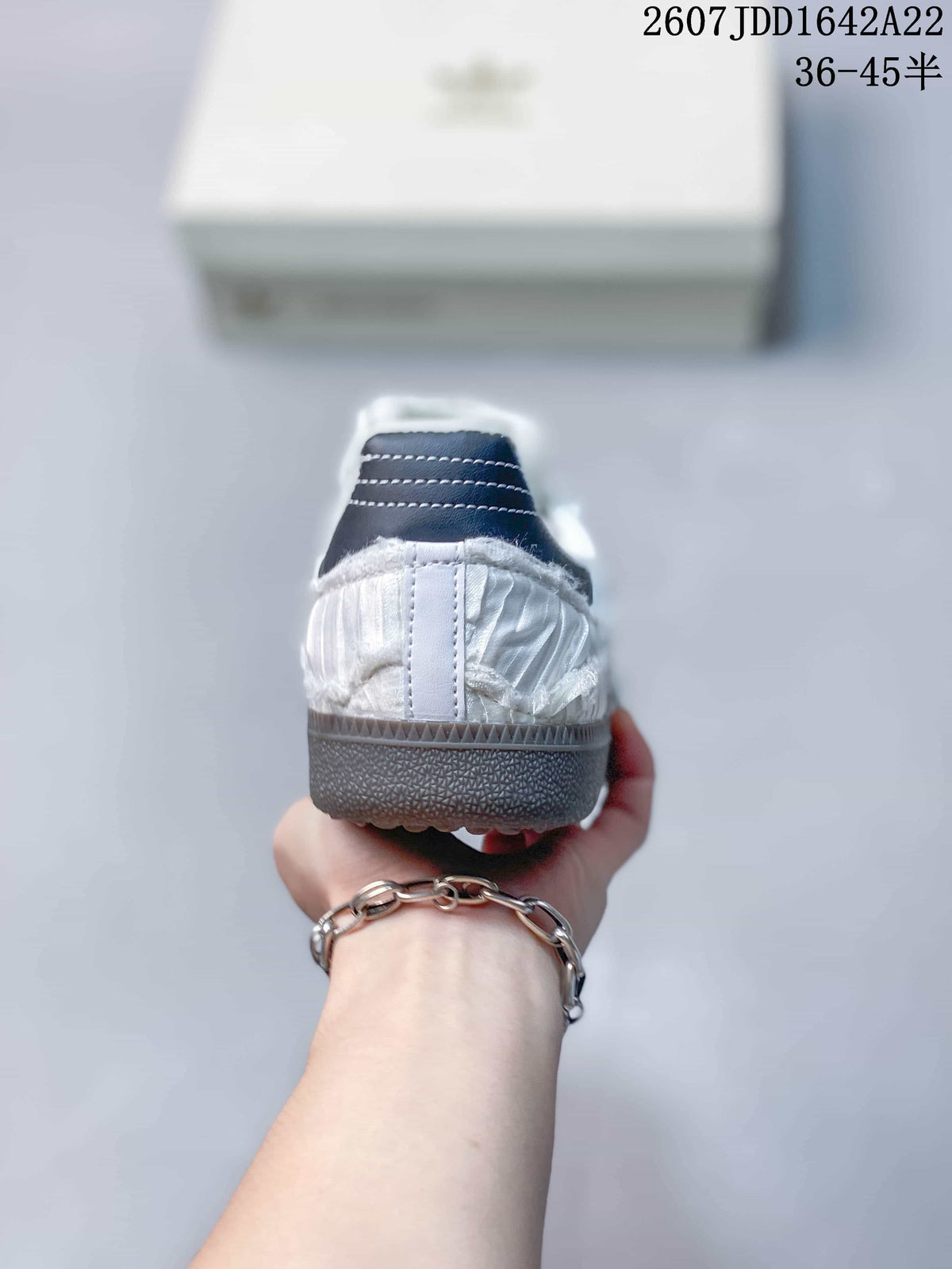 Rear view showing the white heel, navy collar detail, and textured outsole.