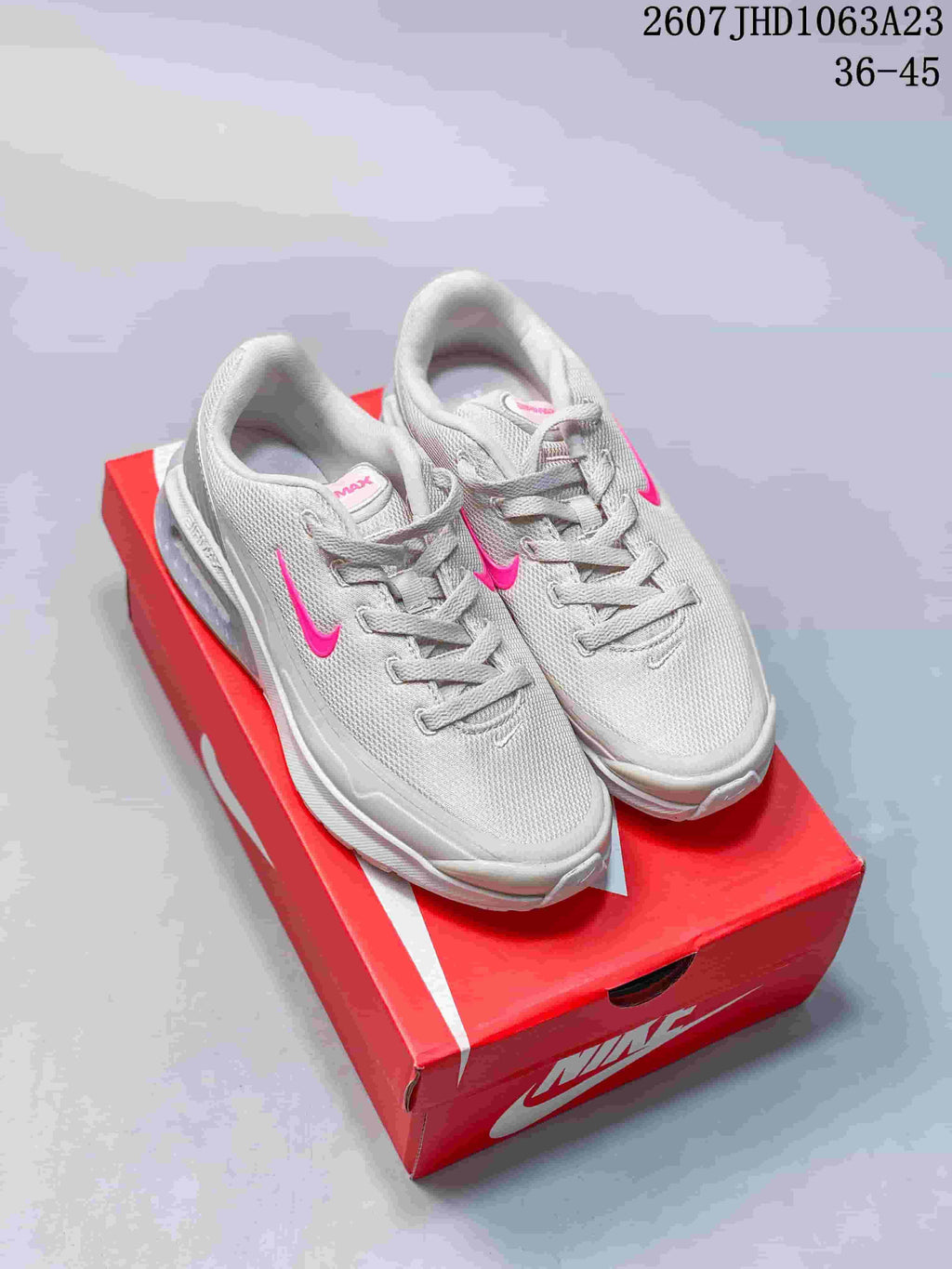 Pair of white and pink Nike Air Max Viva sneakers displayed on a red shoebox.