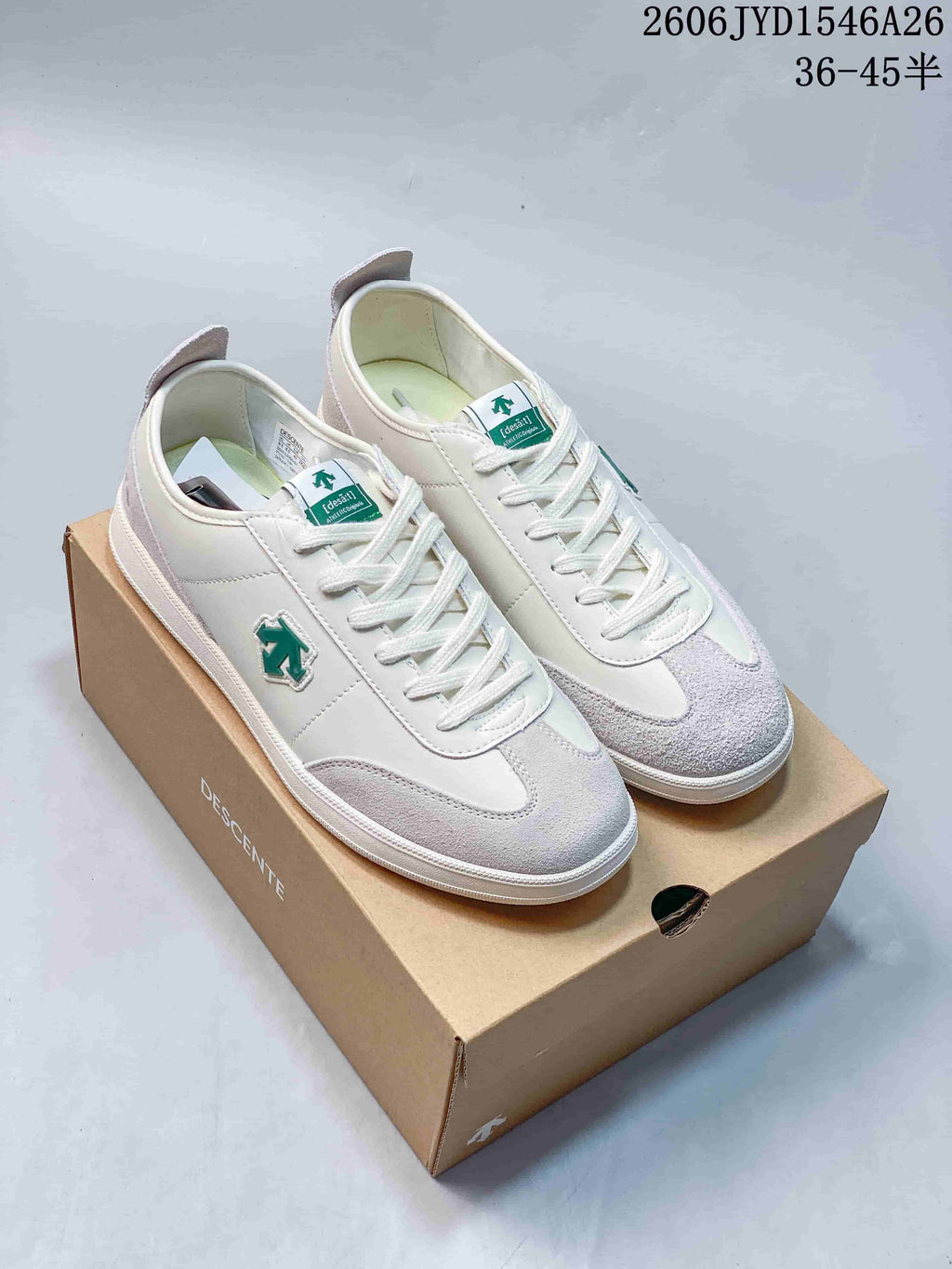 Pair of white and pale gray low-top sneakers with green accents