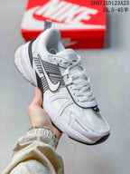Angled side view showing the white mesh-style upper, layered overlays, side logo, and chunky midsole.