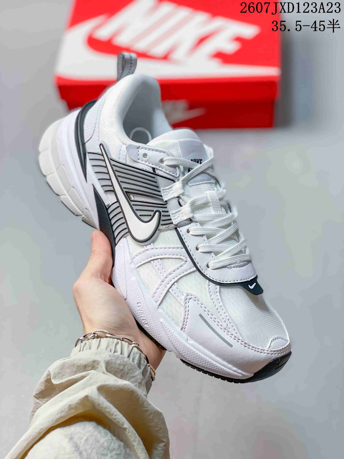 Angled side view showing the white mesh-style upper, layered overlays, side logo, and chunky midsole.