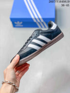 Side profile of the black low-top sneaker showing white three-stripe detailing, a gum sole and low-profile silhouette.