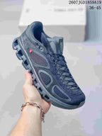 Three-quarter side view of the dark sneaker showing the mesh upper, side panels, lace system, and segmented outsole.