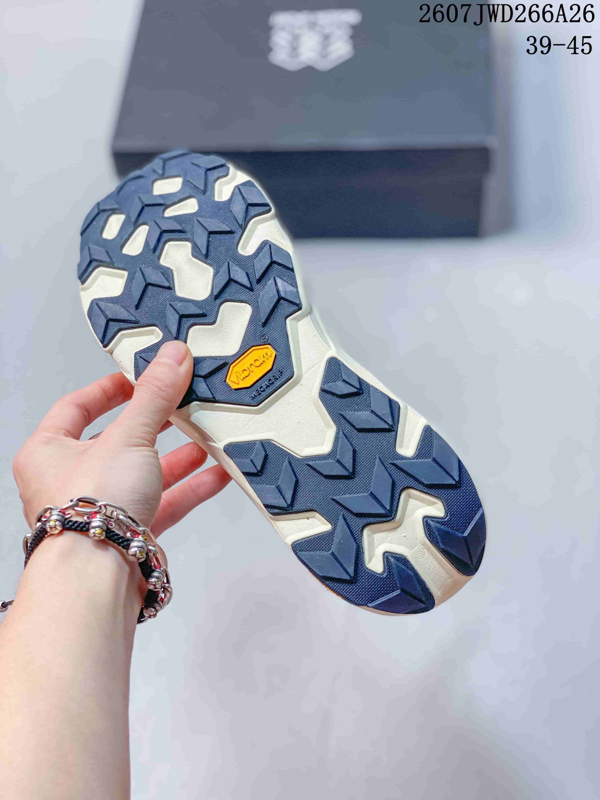 Close view of the lugged outsole showing navy traction sections and a visible Vibram marking.