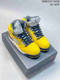 Pair of yellow and gray Air Jordan 5 high-top sneakers shown on a shoe box