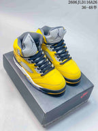 Pair of yellow and gray Air Jordan 5 high-top sneakers shown on a shoe box