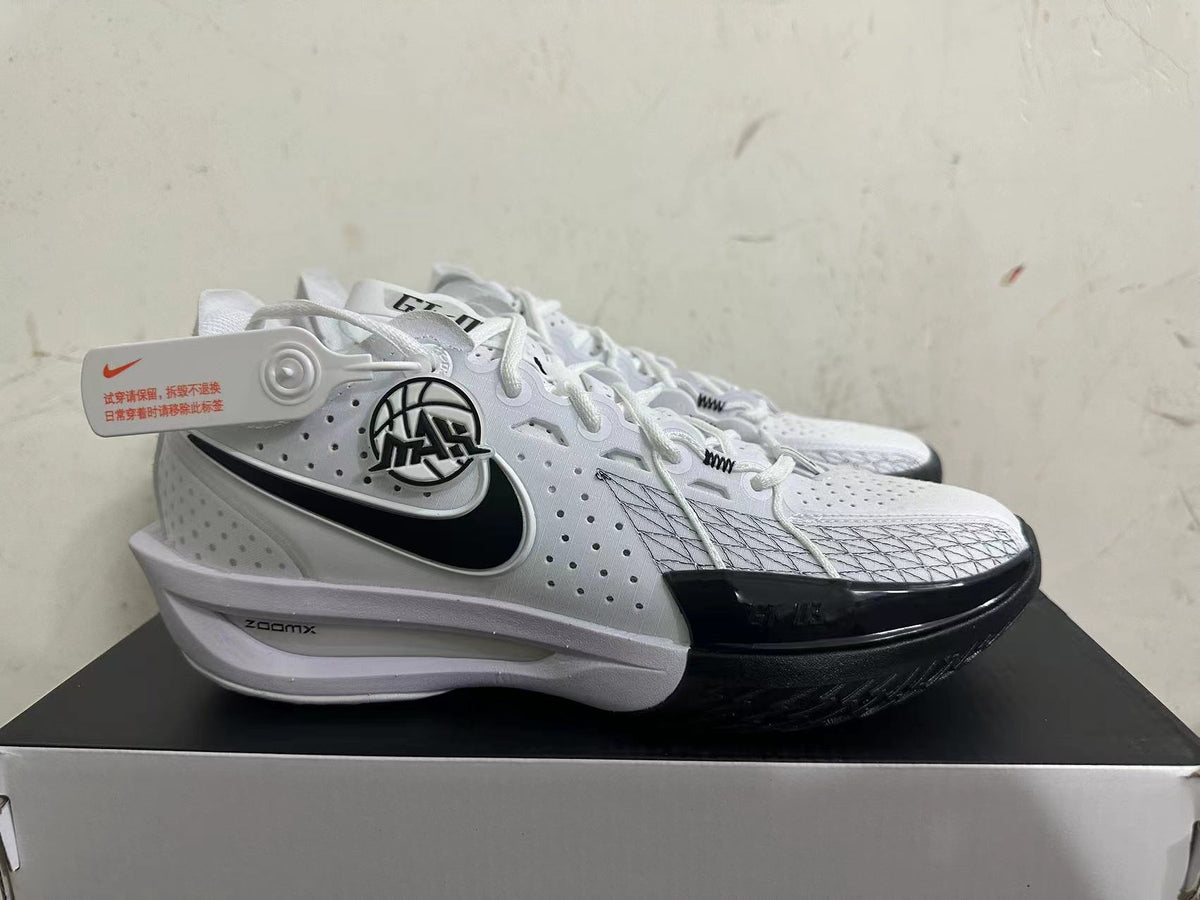 Side view of white Nike basketball shoes with a black Swoosh and patterned forefoot overlay.
