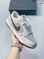 Angled side view showing the white and grey upper, dark swoosh and perforated toe area.