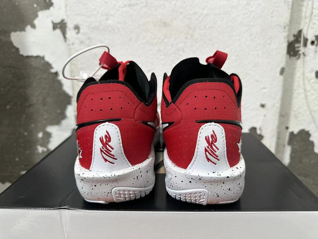 Rear view of red Nike basketball shoes with black collars, white heel panels, and speckled white soles.
