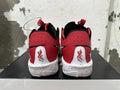 Rear view of red Nike basketball shoes with black collars, white heel panels, and speckled white soles.