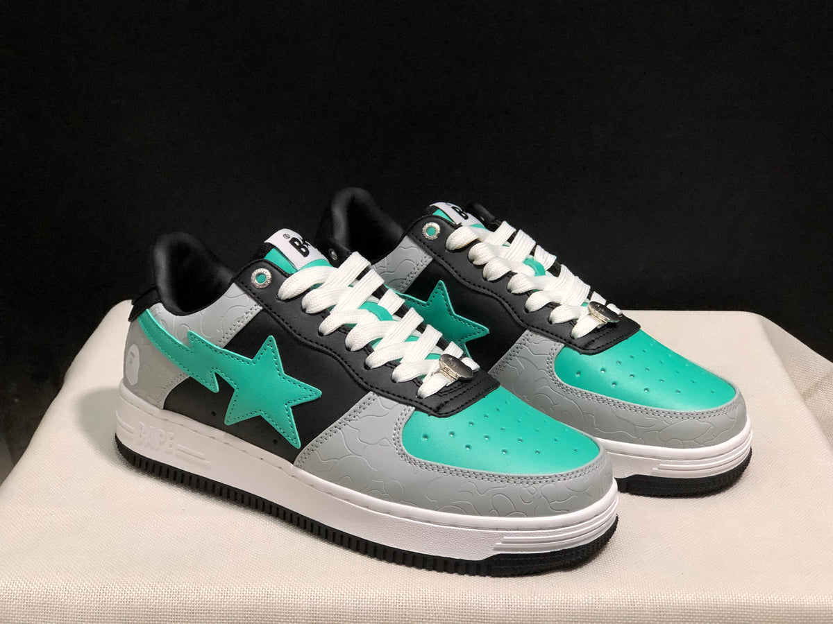 Three-quarter view of the pair showing the star emblems and contrasting black, grey and turquoise upper.