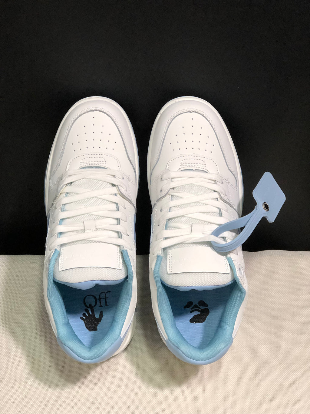 Top view showing white laces, perforated toe panels, light blue padded collars and branded insoles.