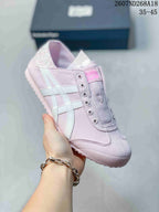 Angled side view of the pink sneaker highlighting the fabric upper, light-colored side stripes and patterned heel detail.