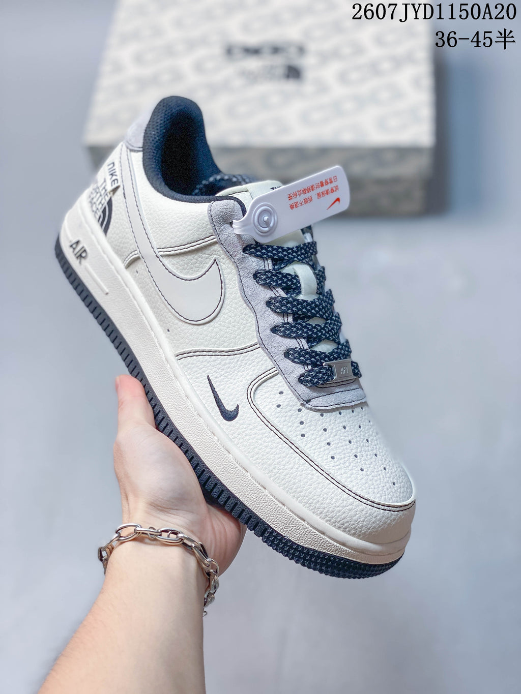 Angled side view of the white sneaker showing the side detail, dark navy laces and contrasting outsole.