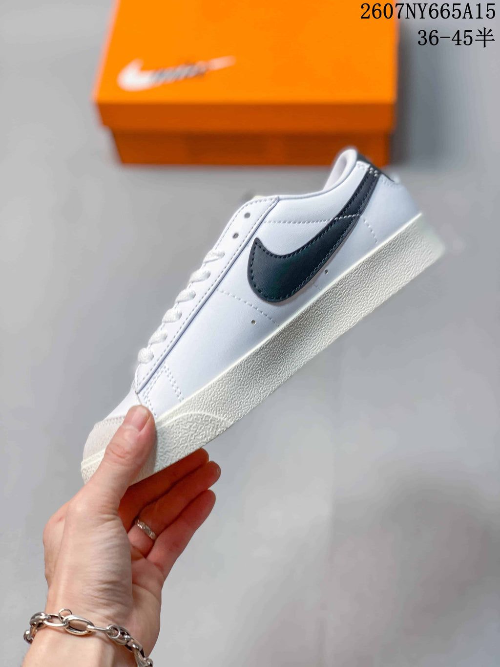 Side profile showing the white upper, black Swoosh, gray toe detail and off-white sole.