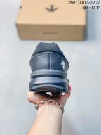 Rear view of the black sneaker showing the padded heel collar, Descente branding and layered outsole.