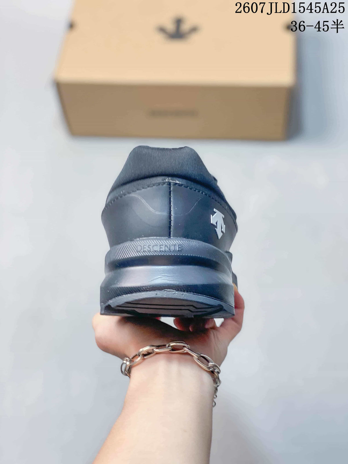 Rear view of the black sneaker showing the padded heel collar, Descente branding and layered outsole.