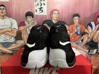 Front view of black and white high-top Nike basketball sneakers with zip-front uppers and visible Swoosh logos.