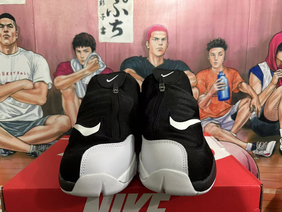 Front view of black and white high-top Nike basketball sneakers with zip-front uppers and visible Swoosh logos.