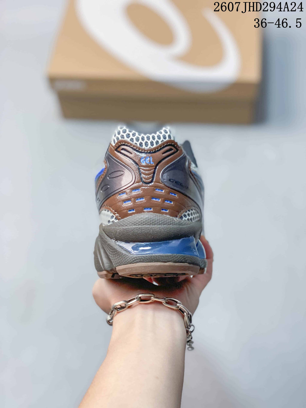 Rear view of the ASICS sneaker showing the layered heel structure, mesh detailing, blue accents, and GEL marking.