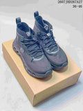 Pair of dark gray LOEWE x On Cloudtilt high-top sneakers displayed on a tan shoebox, with the 36-46 size range and source code visible at the top.