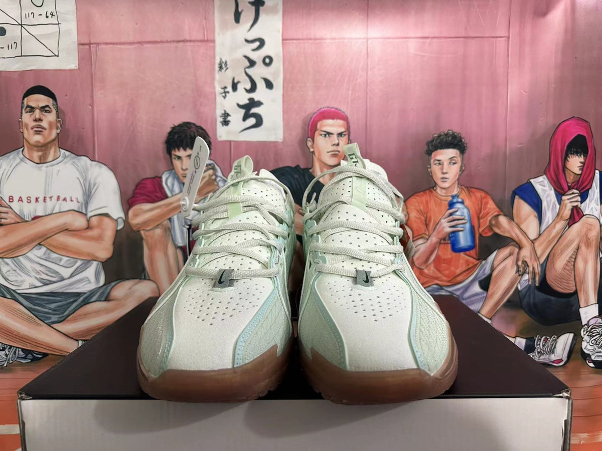 Front view of pale green and white Nike G.T. Jump 2 shoes with perforated uppers and brown-toned outsole sections