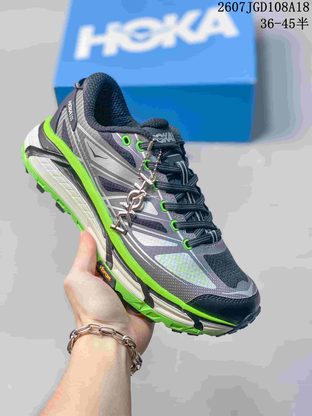 Dark gray HOKA Mafate Speed 2 sneaker with vivid green eyelets and outsole accents.