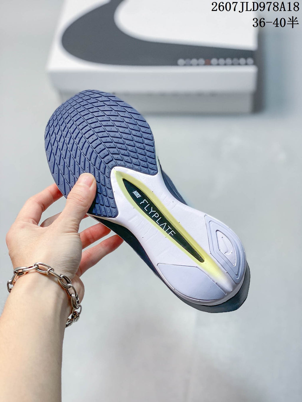 Close view of the sneaker outsole showing textured dark rubber and a visible Flyplate marking.